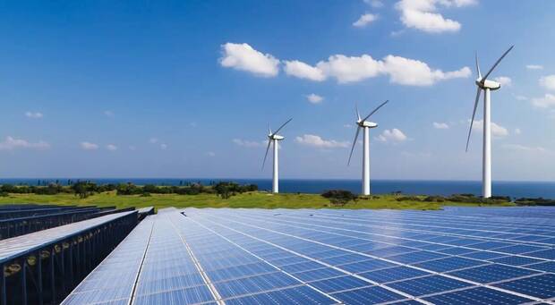 Imagen de un campo de células fotovoltaicas y aerogeneradores (El Español)