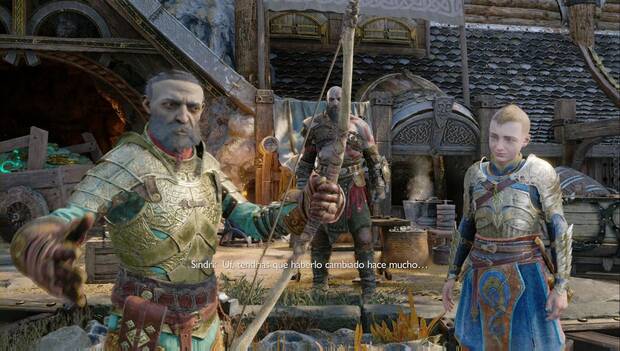 God of War: Ragnarok - En busca de Tyr: Sindri en primer plano, mirando a cámara y examinando el arco de Atreus. Al fondo, Atreus y Kratos observan la operación