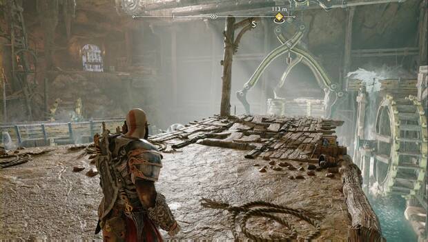 God of War: Ragnarok - En busca de Tyr: Kratos en la plataforma central de una de las últimas salas de El corazón de la manzana. A su izquierda hay una artesa bloqueada por rocas verdes, lo que hace girar una rueda de agua. A su derecha, hay una artesa congelada, el agua se desborda y mueve la segunda rueda