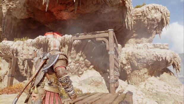 God of War: Ragnarok - En busca de Tyr: Kratos justo debajo de un cofre de materiales. Frente a él hay una estructura de madera por la que se puede trepar