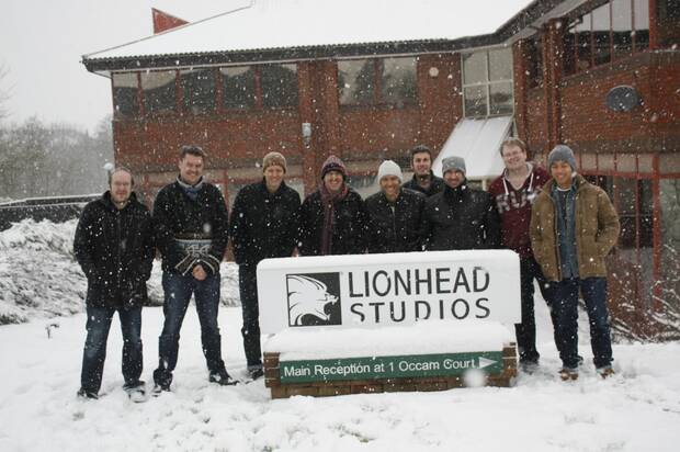 Parte del equipo de Lionhead ante el cartel del estudio.