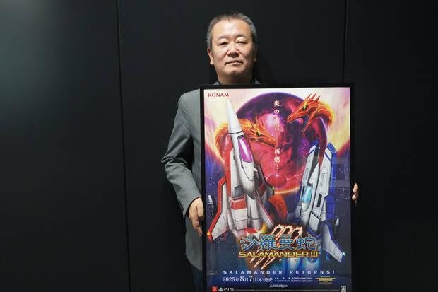 Fotografía de Ryosaku Ueno, productor de Gradius Origins, con un cartel de Salamander 3.