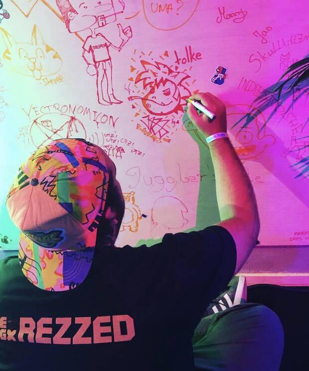 Jacob Jazz firmando en el indiewall de Colonia (Alemania) junto a un dibujo de Watracio Walpurgis.